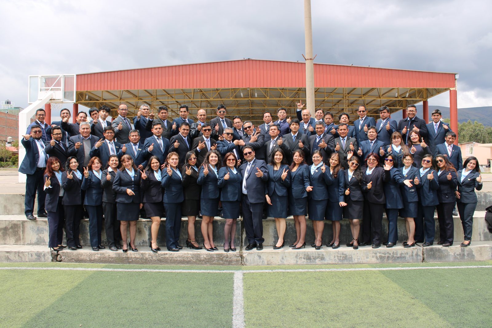 Colaboradores y docentes del colegio reunidos en el patio