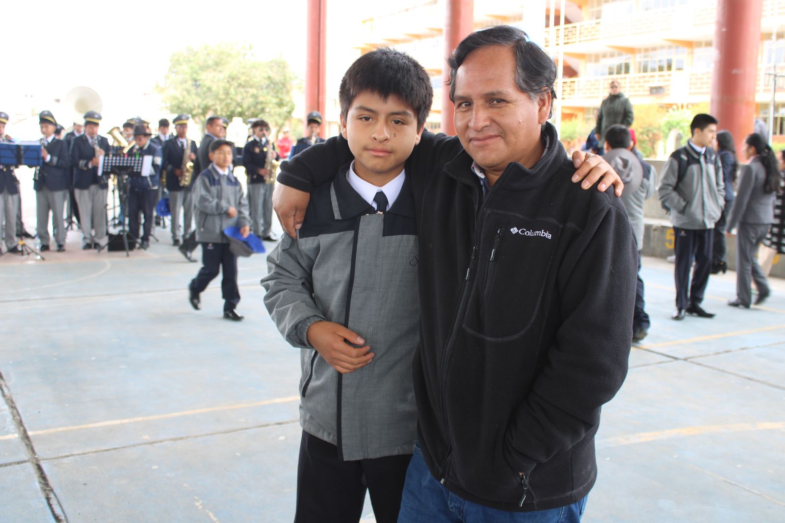 Un padre de familia abraza a su hijo en el patio del colegio
